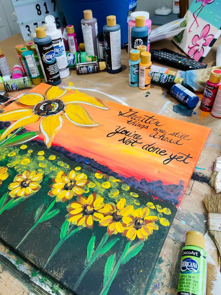 acrylic painting of sunflowers by Heidi Easley with bottles of acrylic paint