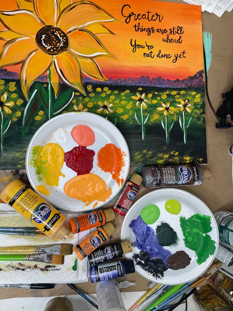 acrylic painting of a sunflower landscape with bottle of paint