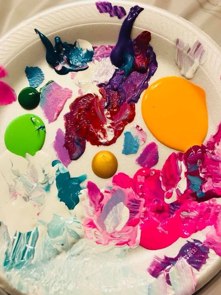 Paper plate filled with colorful paints