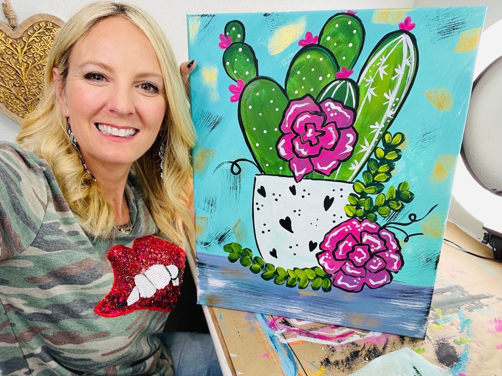Heidi Easley with an acrylic painting of a cactus in a flower pot