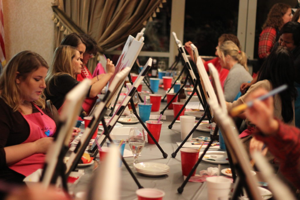 group of women painting while listening to a playlist on spotify