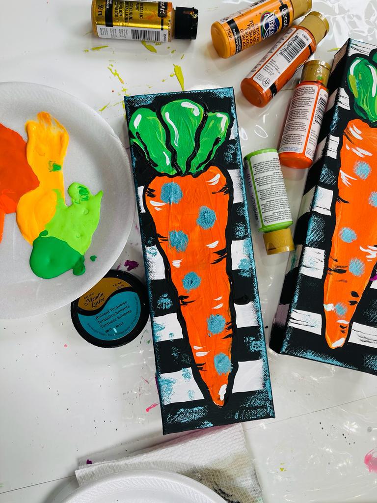 finished carrot painting next to paints