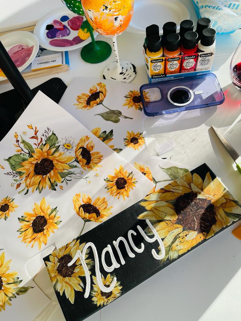 Painted black canvas with sunflowers and Nancy on it
